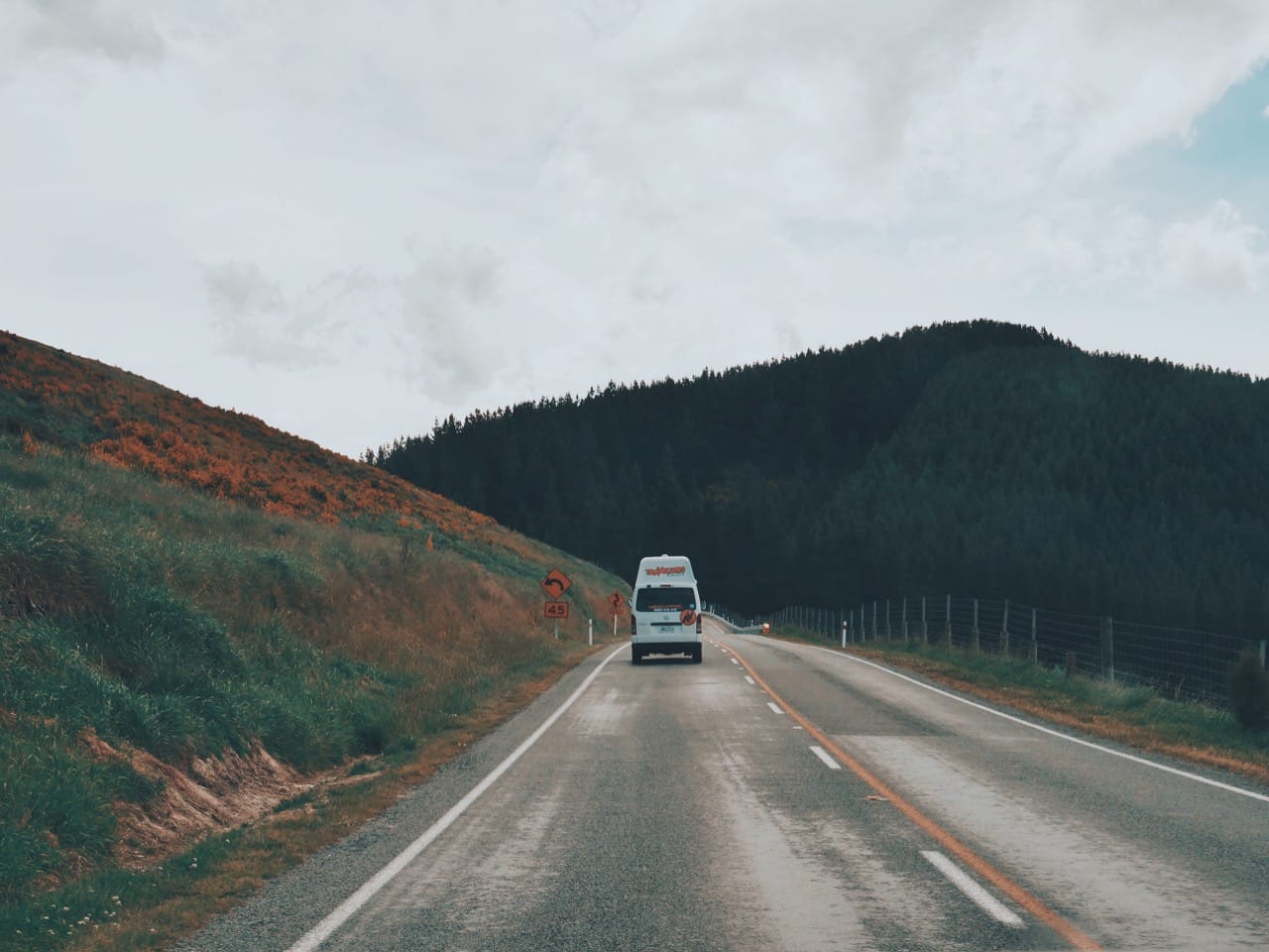 van on the road with mountains in the background